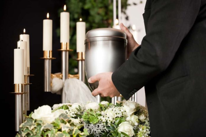 A citizen holding the cremated remains of their loved one.