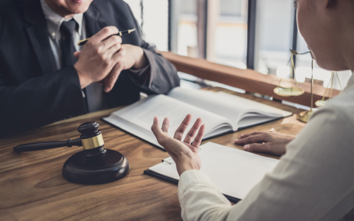 two people sitting at a table with paperwork in front of them