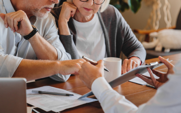 elderly couple reviewing paperwork at a table