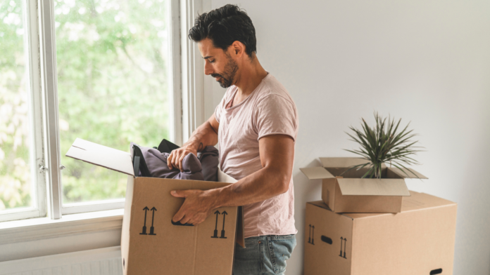 man unpacking moving box