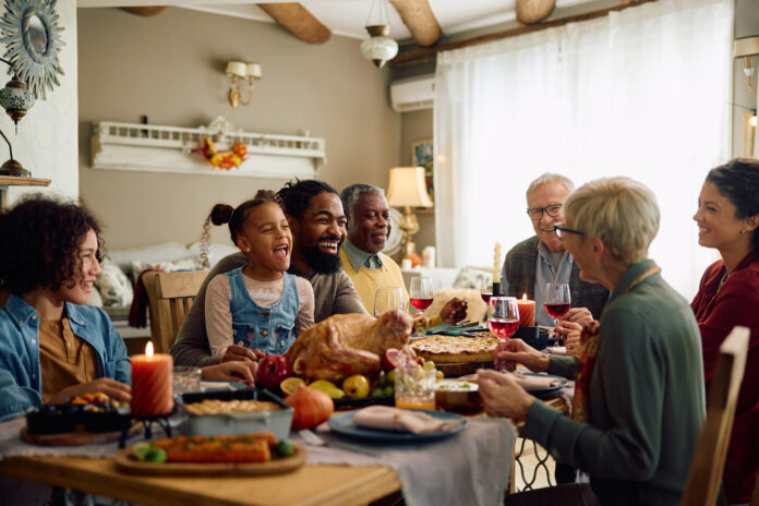 Cheerful family enjoying in conversation during Thanksgiving meal at dining table.